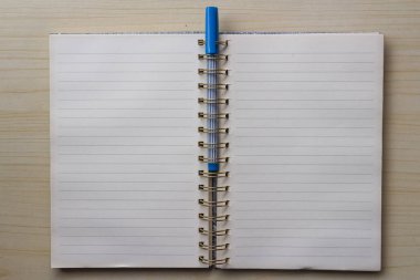 Boş bir defter ya da tahta bir masa üzerindeki kalem ile yüzük klasörünü aç