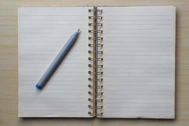 Boş bir defter ya da tahta bir masa üzerindeki kalem ile yüzük klasörünü aç