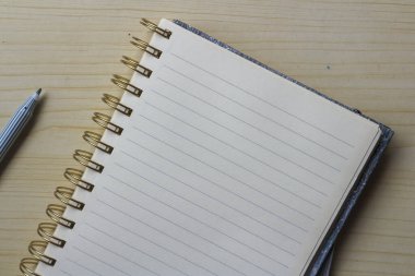 Boş bir defter ya da tahta bir masa üzerindeki kalem ile yüzük klasörünü aç