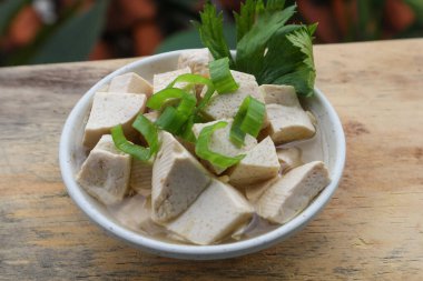 Tahta masadaki kasede taze beyaz tofu.