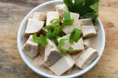 Tahta masadaki kasede taze beyaz tofu.
