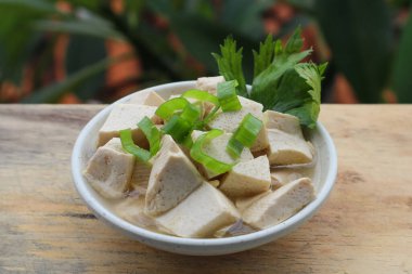 Tahta masadaki kasede taze beyaz tofu.