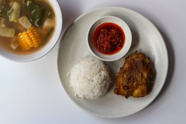 Pilavlı kızarmış tavuk ve beyaz arka planda Sayur asem.