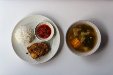 Pilavlı kızarmış tavuk ve beyaz arka planda Sayur asem.