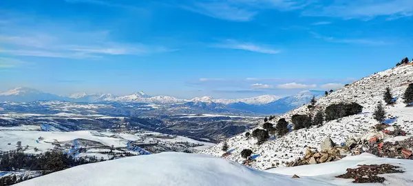 Dağları ve mavi gökyüzü olan güzel bir manzara.