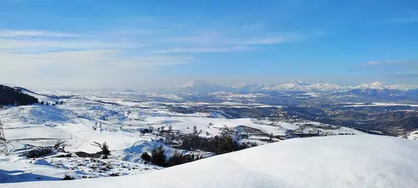 Kışın karla kaplı dağlar ve tepelerin yatay görüntüsü