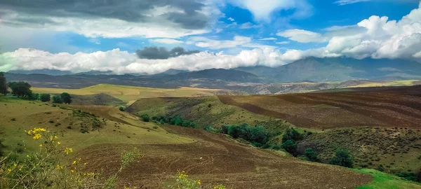 Yağmur yağan kalın beyaz bulutlar toprağı ve otları sulamaya geliyor.