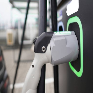 Şarj istasyonunda bir elektrikli aracı şarj etme işlemi sırasında şarj prizine bağlı bir elektrikli şarj cihazı
