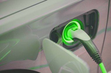 Şarj istasyonunda bir elektrikli aracı şarj etme işlemi sırasında şarj prizine bağlı bir elektrikli şarj cihazı