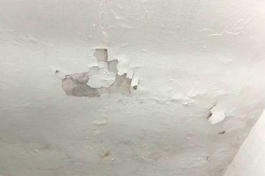 Beyaz duvarlar dökülüyor, rutubet yüzünden soyuluyor, eski duvar dokusu arka planda, arka planda çizikler ve çatlaklar olan beyaz beton bir duvarın dokusu