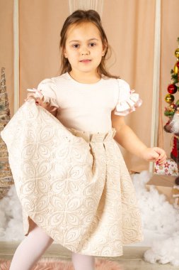 Şampanya elbiseli küçük kız poz veriyor