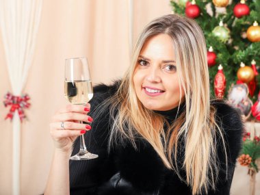 Bir kadeh şampanyayla evde bir kadın.