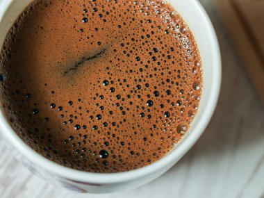 Kahve fincanının makro görüntüsü, üzerinde kabarcıklar var, yakın açı görünümü var.