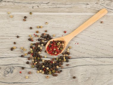 Tahta masadaki kaşıklarda farklı türde kuru biber.