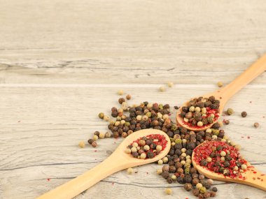 Tahta masadaki kaşıklarda farklı türde kuru biber.
