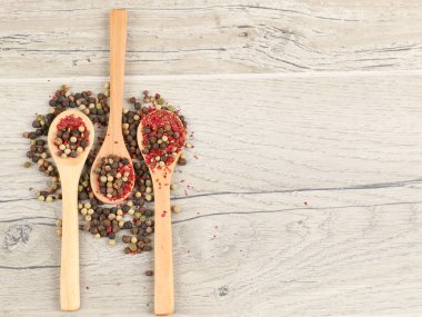 Tahta masadaki kaşıklarda farklı türde kuru biber.