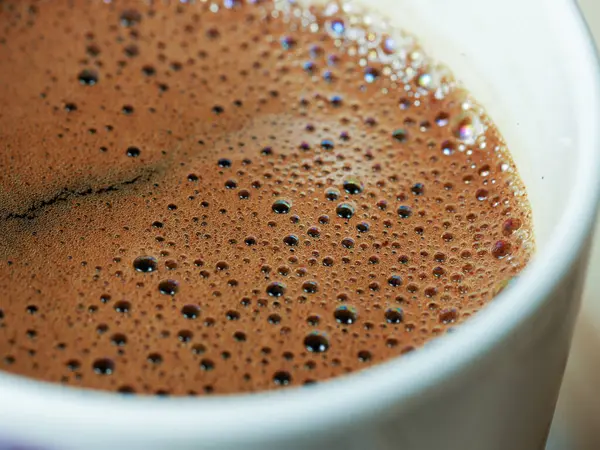 Kahve fincanının makro görüntüsü, üzerinde kabarcıklar var, yakın açı görünümü var.