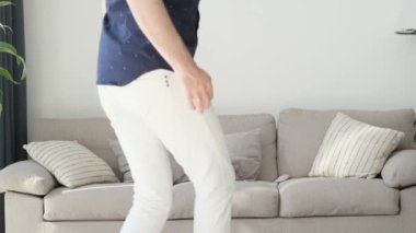 Gülümseyen aile koşuyor ve kanepede oturuyor, anne, baba ve çocuklar evde birlikte vakit geçiriyorlar. Ailede mutluluk.