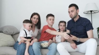 Beş kişilik bir aile - baba, anne, kız ve oğullardan oluşan bir aile akşam televizyon izliyor. Neşeli bir aile evdeki kanepede dinlenip çocuklarla film izliyor..