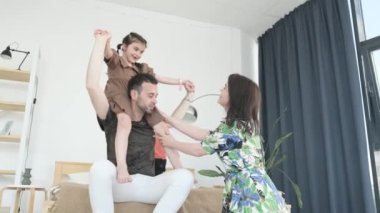 Gülümseyen baba çocuklarla oynuyor, mutlu aile anne, baba ve çocuklar evde dinleniyor.