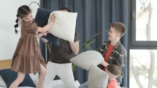 Junge Lächelnde Familie Kämpft Mit Kissen Auf Dem Bett Schlafzimmer — Stockvideo