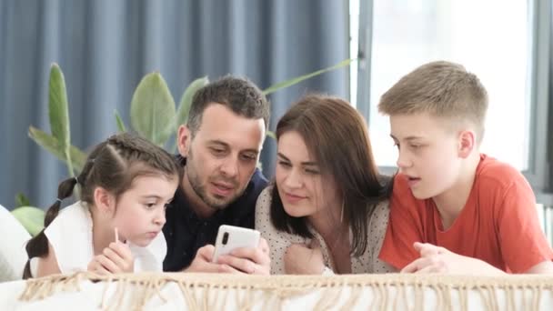 Familia Americana Feliz Acostado Cama Casa Utilizando Gadget Moderno Divierten — Vídeo de stock