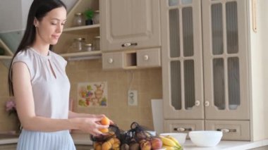 İnce, genç bir esmer meyve aldı. Çevre yemeği. Vejetaryen yemeği. Kendi mutfağında bir kadın