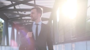 Takım elbiseli genç bir işadamı aceleyle işe gidiyor. Amerikalı işadamı sabah ofise koşar. Çerçevede güneş ışınları