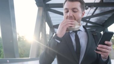 Genç bir yönetici işe gider ve hamburger yer. İş adamı sokak yemeği yer. Yavaş çekim