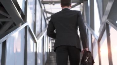 Yakışıklı genç bir işadamı sabah işe gider. Bir ofis çalışanı elinde bir evrak çantasıyla işe koşuyor. Ağır çekim. Yüksek kalite 4k video