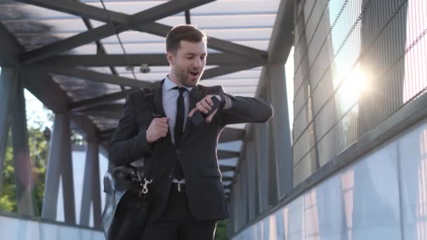 ビジネススーツの若いビジネスマンが仕事に駆けつける アメリカの実業家は午前中に事務所に行く フレーム内の太陽光線 — ストック動画