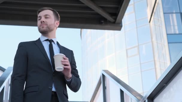 仕事に行く間 ビジネススーツの男性ビジネスマンはコーヒーを飲む アメリカの実業家は午前中に事務所に行く フレーム内の自然光 — ストック動画