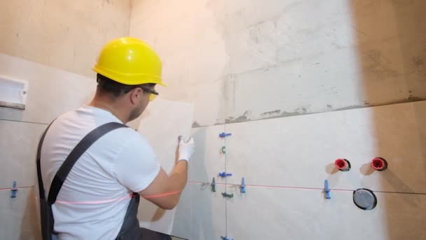 一个铁匠把瓷墙瓷砖放在浴室里 公寓维修专家 — 图库视频影像