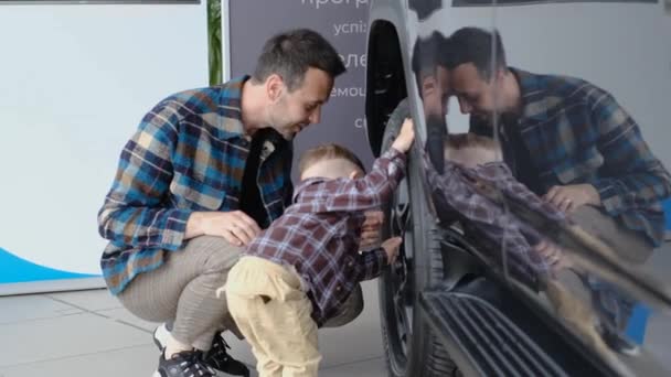 Een Vader Met Zijn Zoontje Onderzoekt Een Nieuwe Auto Bij — Stockvideo