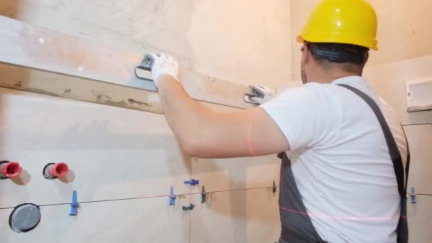 Bau Und Reparatur Einer Wohnung Ein Mann Verlegt Keramikfliesen Einer — Stockvideo