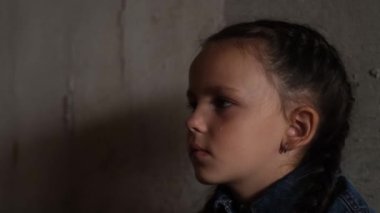 Gözlerinde yaşlarla sığınaklardaki Ukraynalı çocuklar. Bir çocuk roket saldırıları nedeniyle bodrumda. Sığınakta bir çocuk. Ukrayna 'da savaş. 4k video