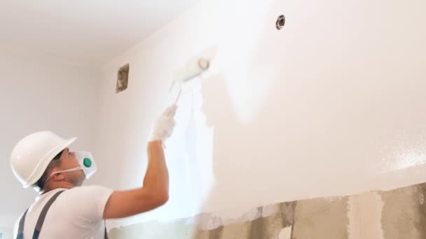 Mężczyzna Maluje Ściany Szaro Wałkiem Malowania Remontuje Nowoczesnym Mieszkaniu Koncepcja — Wideo stockowe