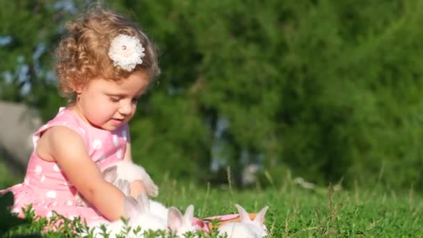 Mała Dziewczynka Bawi Się Białym Zającem Ogrodzie Siedząc Zielonej Trawie — Wideo stockowe
