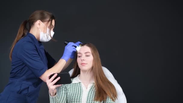 一位年轻妇女由一位专业的三位一体的医生进行检查 美容外科诊所治疗脱发 — 图库视频影像