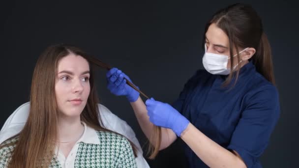 一位专家三叶草学家在一家室内美容院检查顾客的头发 头发脱落治疗概念 — 图库视频影像
