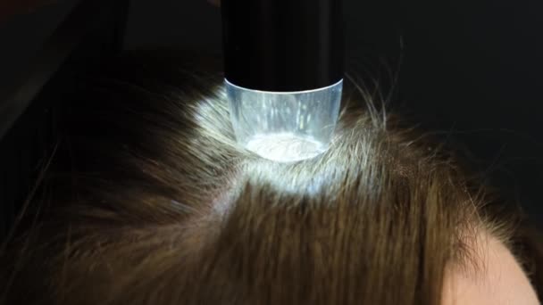 一位专业的医生用皮肤科镜检查一位年轻妇女的头 智能手机 能看到诊所里病人手中的皮肤和头发 4K视频 — 图库视频影像