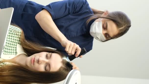 Vídeo Vertical Tricólogo Examina Cabeza Una Mujer Joven Con Dermatoscopio — Vídeos de Stock