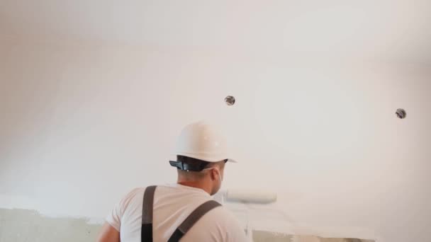Budowniczy Białym Hełmie Maluje Ściany Kolorze Szarym Wałkiem Remontuje Nowoczesnym — Wideo stockowe