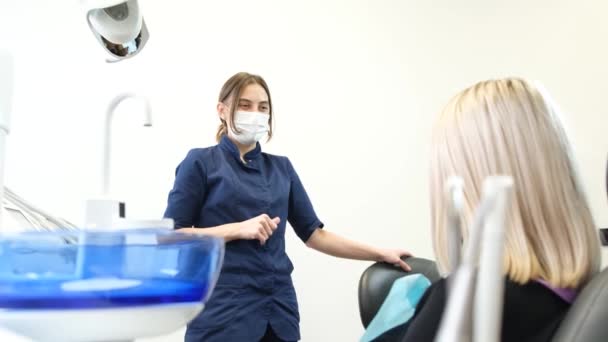 Жінка Стоматолог Розмовляє Пацієнтом Вони Весело Сміються Перед Лікуванням Зубів — стокове відео