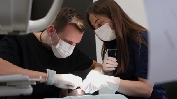 Dwóch Dentystów Podczas Leczenia Zębów Pacjenta Praca Dentysty Opieka Zdrowotna — Wideo stockowe
