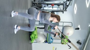 Güzel bir kız kalça kaslarını çalıştırır, çömelme hareketleri yapar. Spor salonunda antrenman. Sağlıklı Yaşam Tarzı