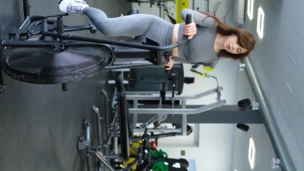 Dziewczyna Rowerzysta Wykonuje Trening Cardio Siłowni Sportowiec Crossfit Pionowe Wideo — Wideo stockowe