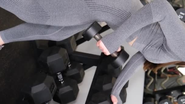 실용적 아름다운 소녀가 군침으로 근육을 훈련시키는 체육관에서의 — 비디오