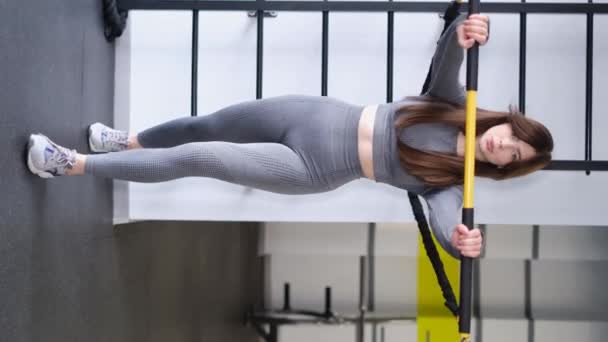亚洲女孩在体育馆里锻炼胳膊肌肉 健康生活方式的概念 垂直录像 — 图库视频影像