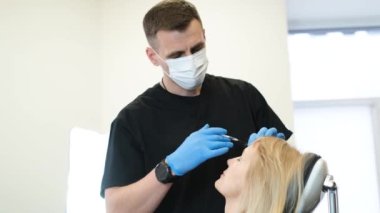 Dudak büyütme işlemi enjeksiyon kullanılarak yapılır. Yaşlı bir kadın bir estetik cerrah tarafından tedavi ediliyor. Yaşlı kadının estetik estetik ameliyatı
